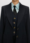 Navy three-piece suit with gold buttons on a plain background