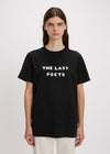 Person wearing a black t-shirt with 'THE LAST POETS' text on a plain background