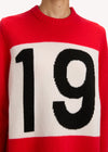 Red sweater with a white square and black number '19' on a plain background