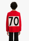 Person wearing a red sweater with a large number '70' on the back against a white background